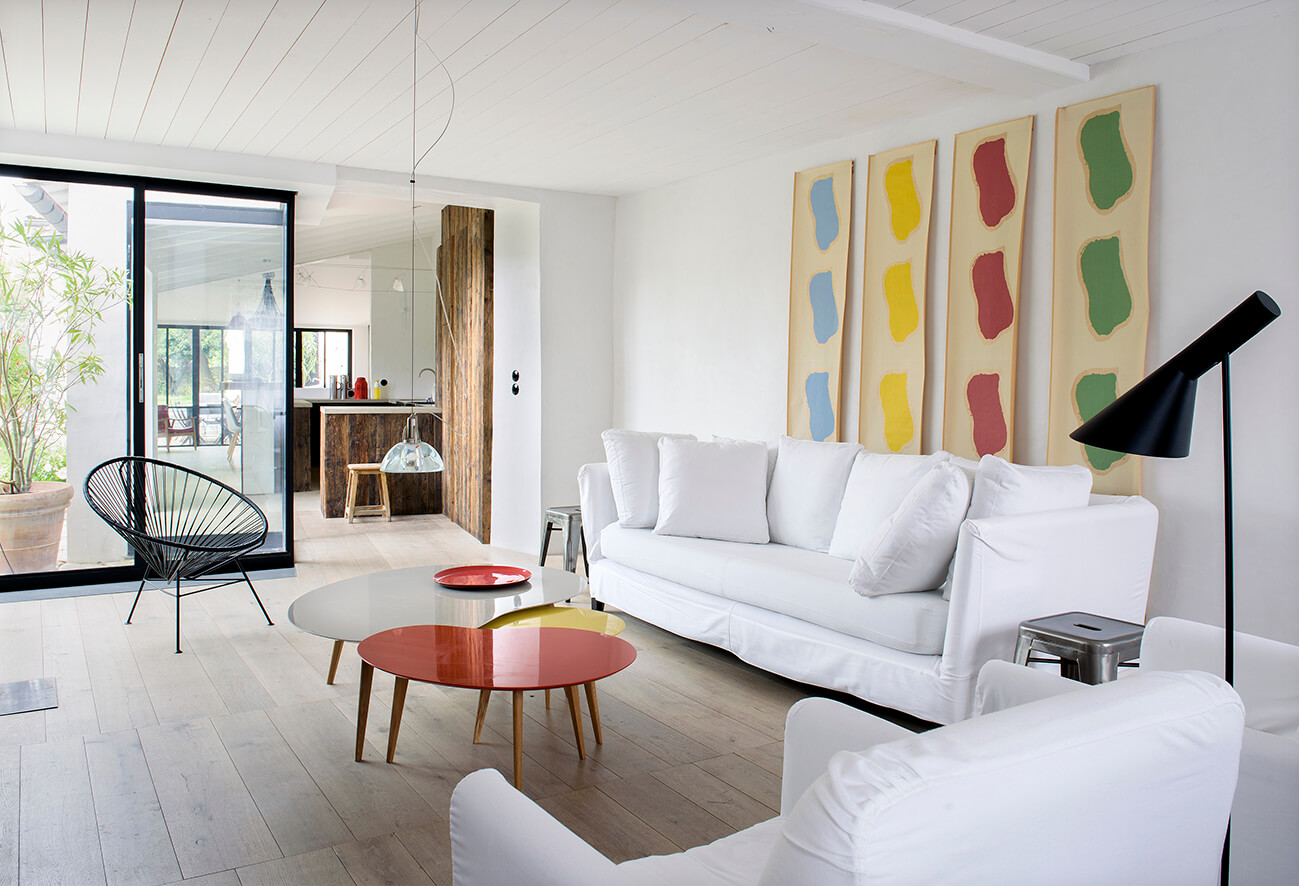 Salon maison contemporaine avec un canapé blanc et une table rouge