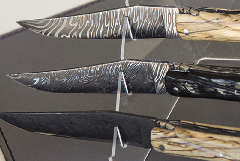 3 couteaux en mettant en valeur les lames damas d'artisans coutelier