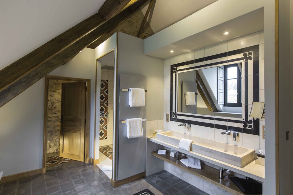 La salle de bains de la chambre «Épervier» accueille une grande douche à l’italienne en carreaux de ciment dans une ambiance campagne chic.