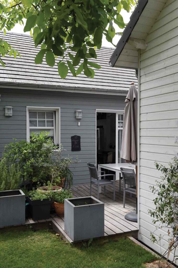 Entre la cuisine et la salle à manger, la petite terrasse ombragée propose une halte intime dans le jardin de centre-ville.