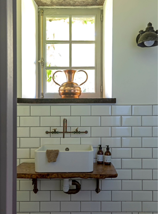 Cette salle de bains dévoile un côté ancien et rustique avec son robinet créé par les ouvriers à l’aide de tuyaux en cuivre.