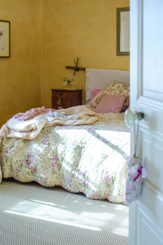 La tête de lit est le résultat d’un DIY réalisé avec une branche trouvée dans la forêt et un ancien tissu en coton blanc.