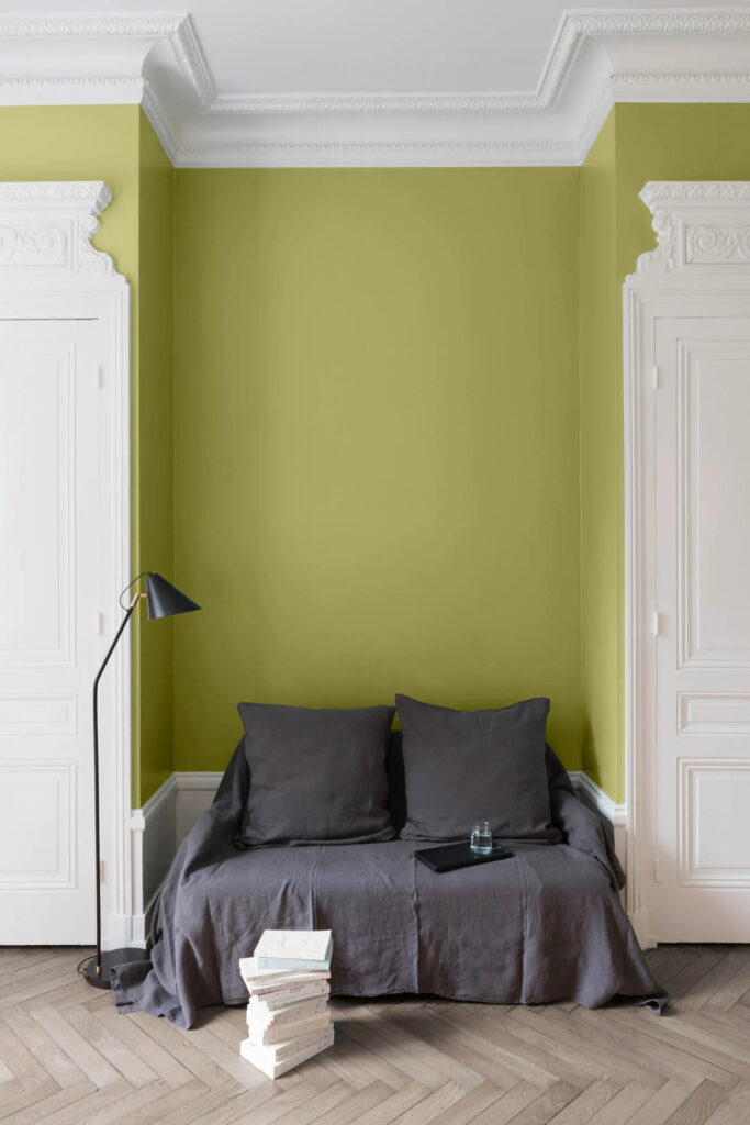 chambre avec un lit et un mur peint en vert