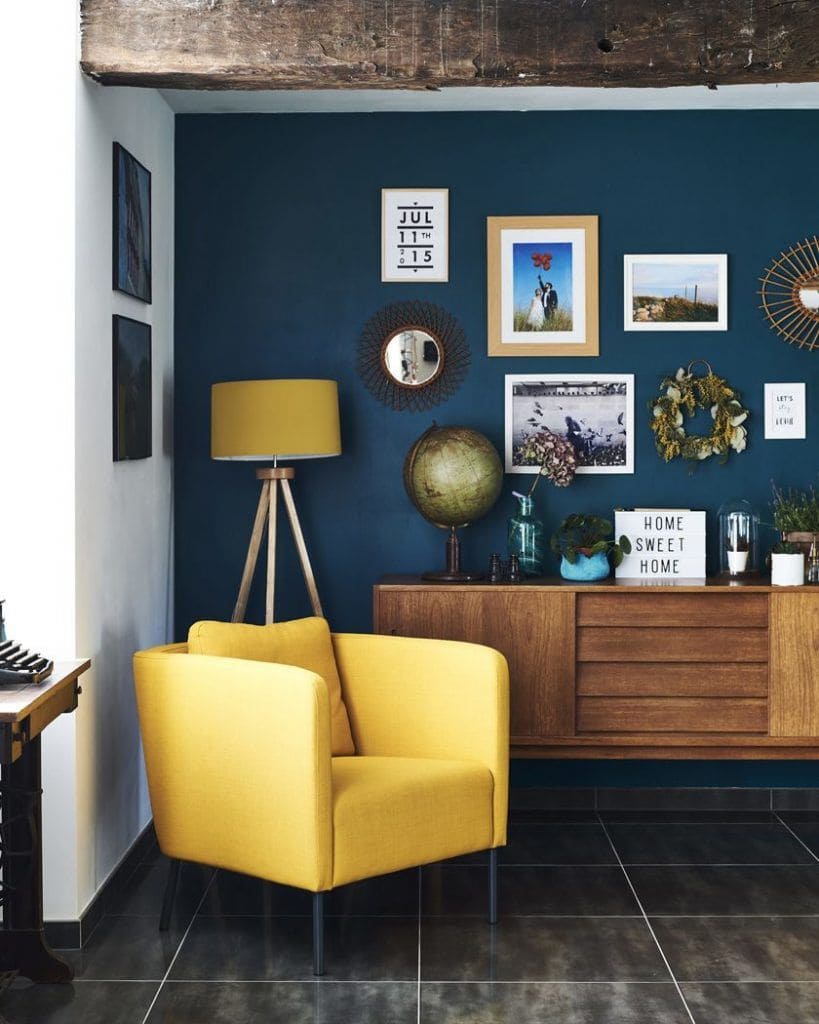 salon avec fauteuil jaune et mur de couleur bleu pétrole