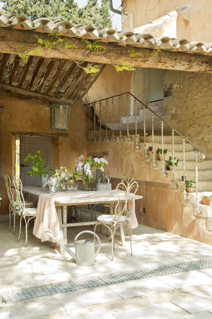 La terrasse entourée de murs recouverts de lierre e a été meublée de chaises et d’une table du designer espagnol félix lozal.