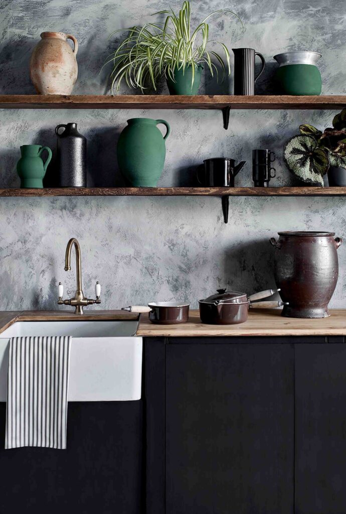 cuisine avec mur gris et étagère sur laquelle est déposé differentes vaiselles